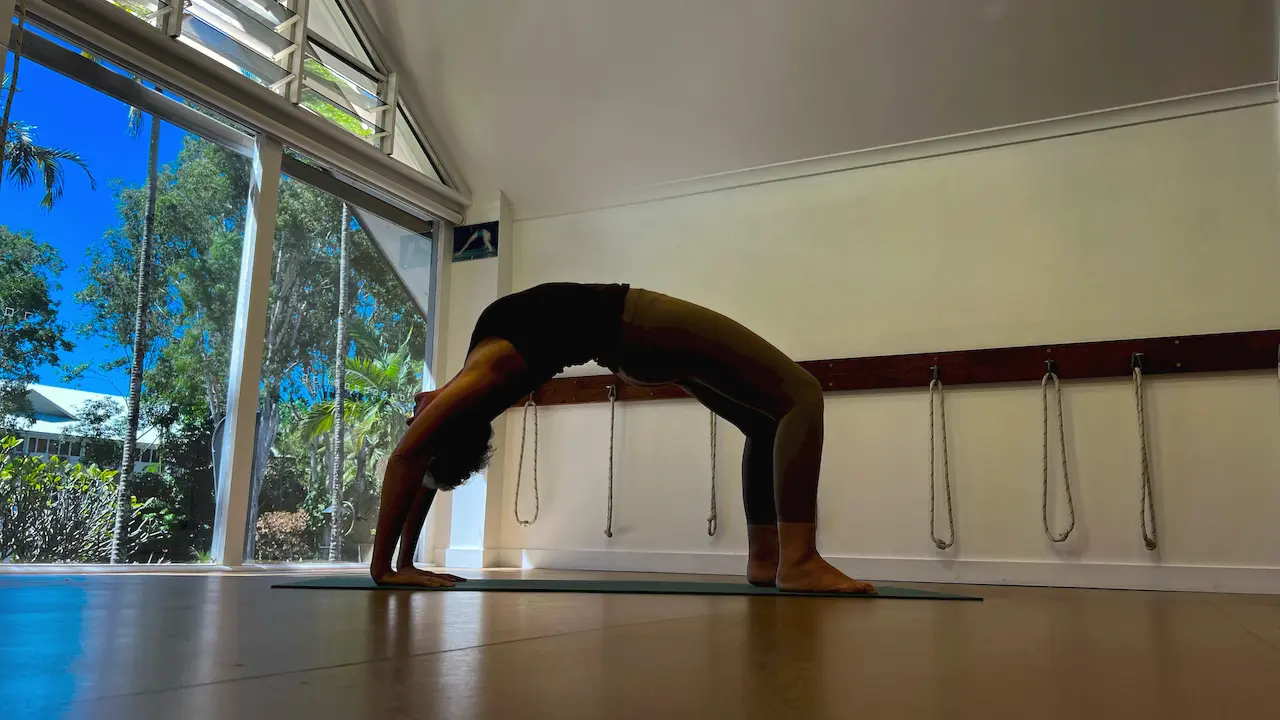 Susan Stackhouse in a full backbend, Urdhva Dhanurasana, on a mat in the studio